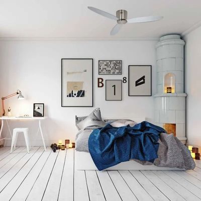 Lit moderne dans une chambre lumineuse avec écharpe et jeté bleu, poêle en faïence et cadre au mur, ambiance cosy. Destratificateur professionnel non visible.