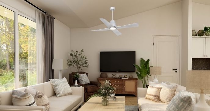 Salon lumineux avec canapé clairs, TV mural et ventilateur de plafond blanc, ambiance cosy et végétation d’intérieur.