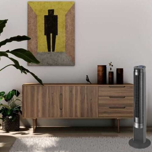 Ventilateur hélicoïdal debout à côté d’une commode en bois dans un salon moderne.