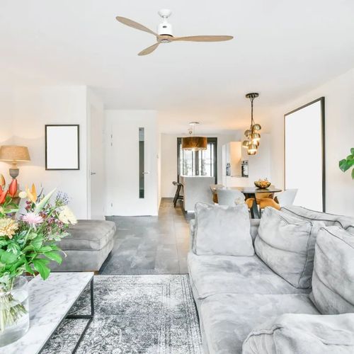 Ventilateur de plafond à trois pales dans un salon lumineux et moderne.