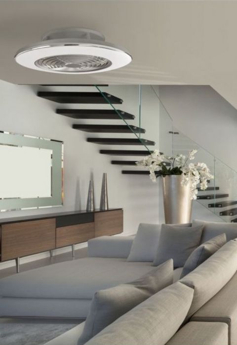 Ventilateur de plafond blanc installé au plafond d’un salon moderne.