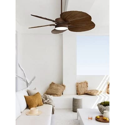 Ventilateur de plafond avec des pales brunes installé au plafond dans un salon lumineux.
